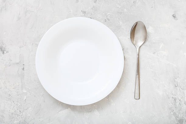 istock top view of white deep plate and spoon on concrete 617575152