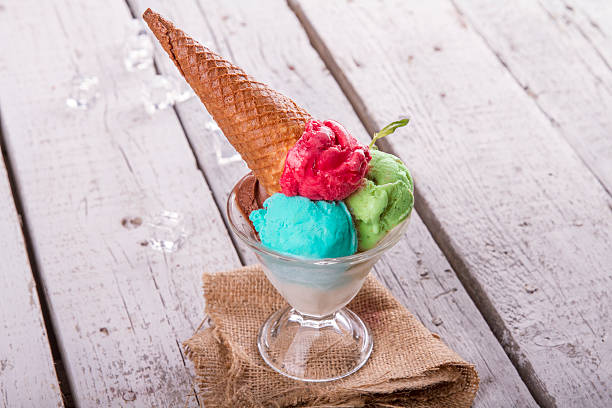 istock Ice cream in cup with cone on a wooden table 617575886