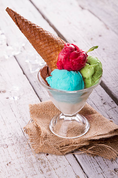 istock Ice cream in cup with cone on a wooden table 617575946