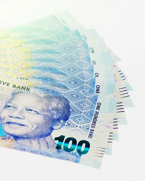 Cropped shot of a sheaf of fanned-out One Hundred Rand banknotes,  featuring the late iconic statesman Nelson Mandela.