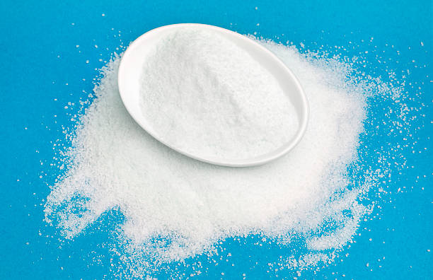 istock White sugar in bowl isolated on blue 617576126