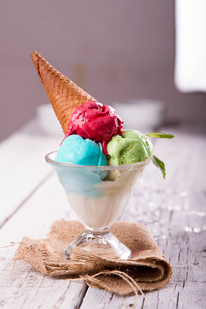 istock Ice cream in cup with cone on a wooden table 617576128