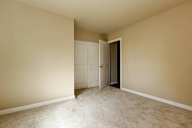 istock Empty beige room with carpet floor and a closet 617576234