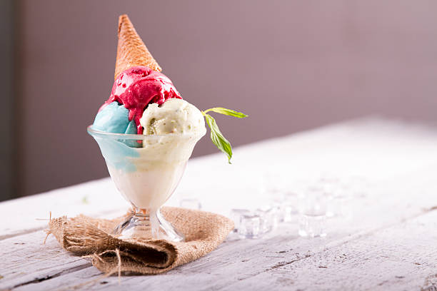 istock Ice cream in cup with cone on a wooden table 617576436