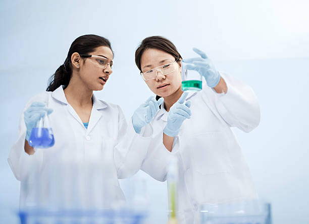 Two women scientists working in a laboratory with chemicals.