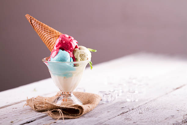 istock Ice cream in cup with cone on a wooden table 617576516