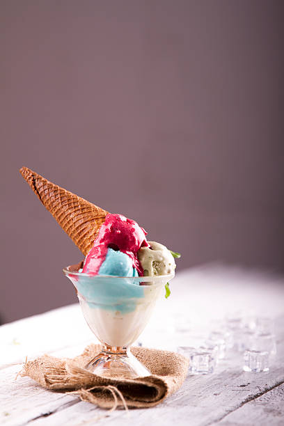 istock Ice cream in cup with cone on a wooden table 617576570