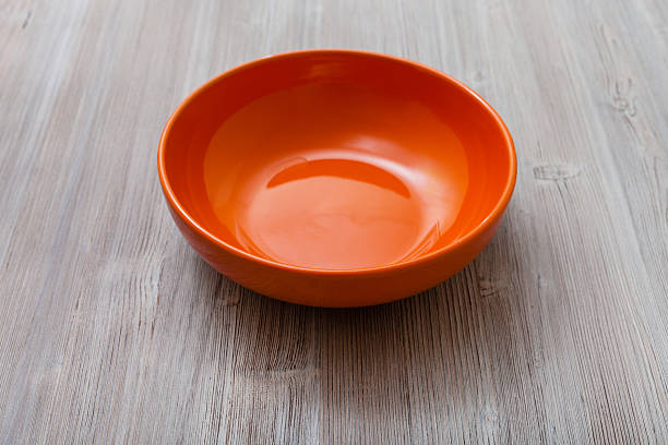 istock orange bowl on gray brown board 617576816