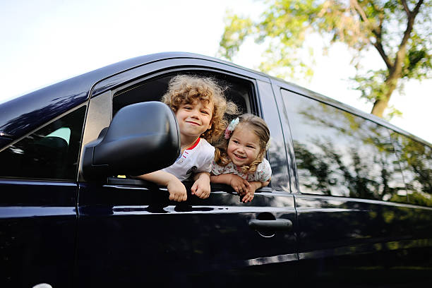 istock children look out from a car window 617580626