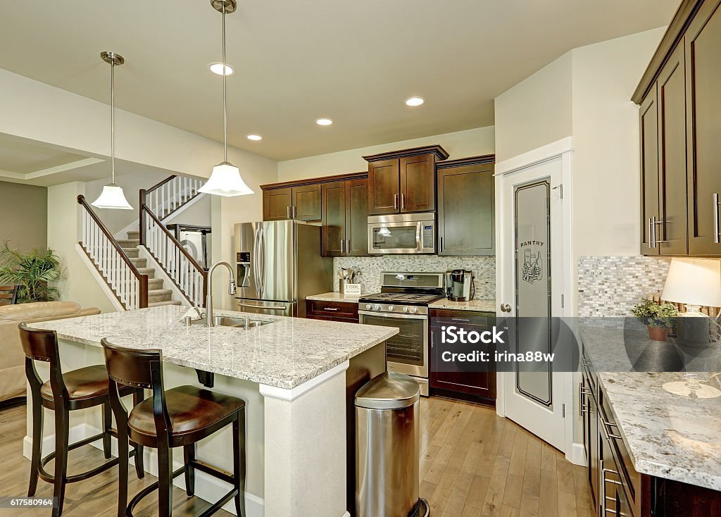 Classic kitchen room interior with large kitchen island Classic kitchen room interior with large kitchen island with granite counter tops,  modern cabinets, stainless steel appliances and pantry. Northwest, USA Granite - Rock Stock Photo