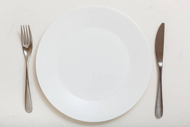 istock top view of white plate with knife, spoon on white 617581766