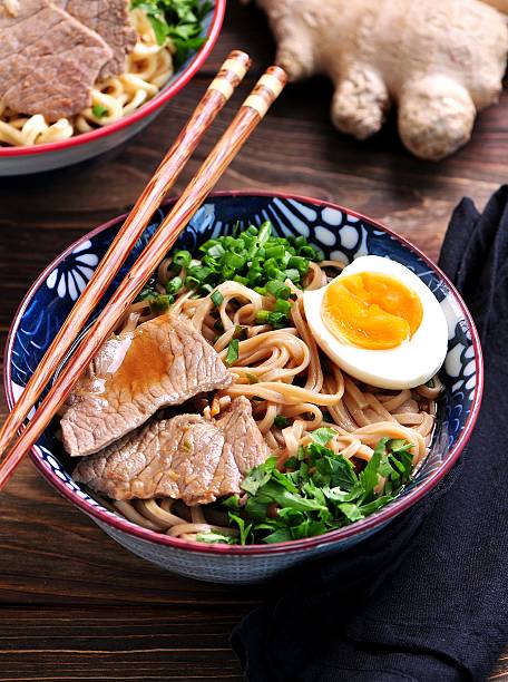 Soup with soba and ramen noodles, beef, ginger, green onions