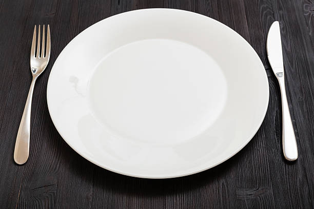 istock white plate with knife, spoon on dark brown table 617582162