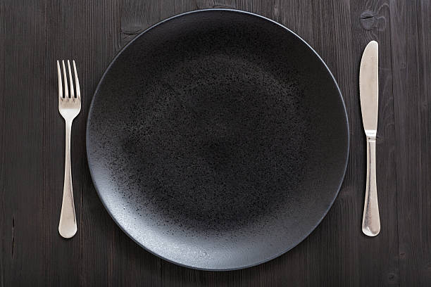 istock top view of black plate with knife, spoon on dark 617582540