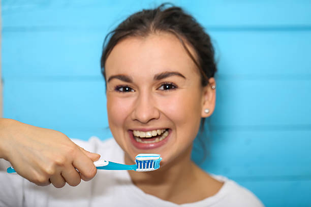 istock girl with toothbrush and toothpaste 617583336