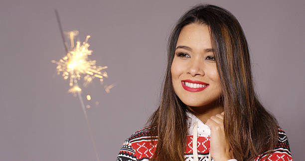 istock Attractive young woman celebrating with a sparkler 617584722