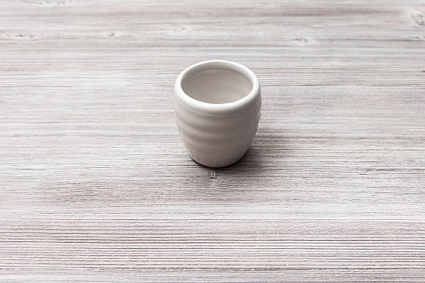 istock white cup for sake on gray brown wooden table 617585304