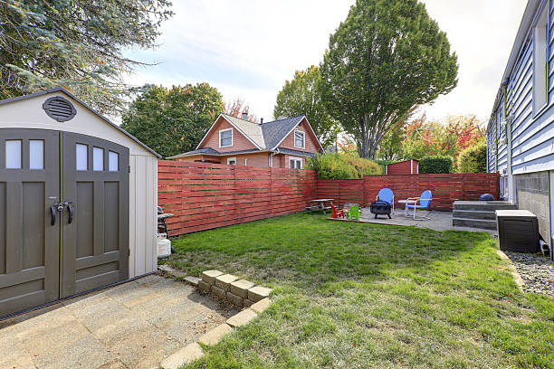 istock Fenced back yard with patio area and barbecue grill 617585818