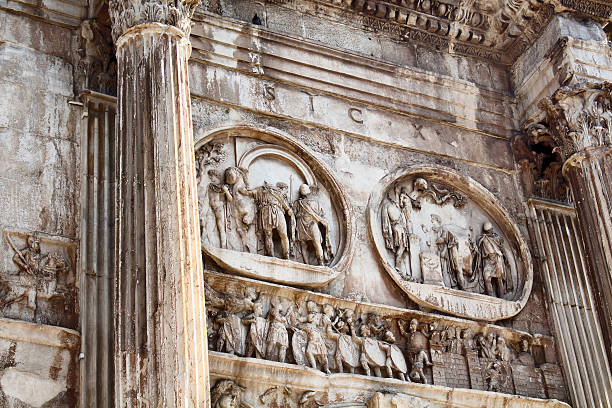 Close up view of arch of Constantine (Arco di Costantino) Close up view of arch of Constantine (Arco di Costantino) A 21m-high Roman structure made up of 3 arches decorated with figures & battle scenes in Rome / Italy. costantino stock pictures, royalty-free photos & images