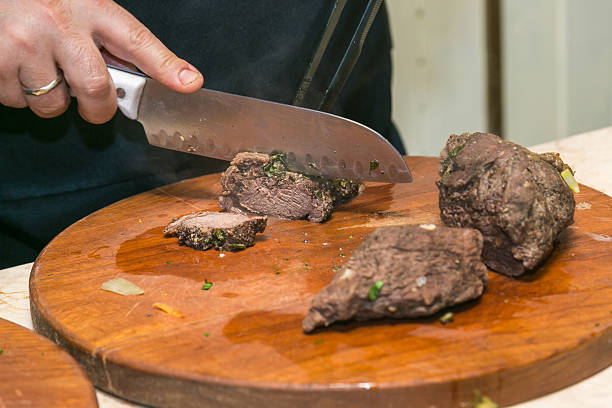 istock Cook cuts roasted beef meat. The concept of cooking 617592414