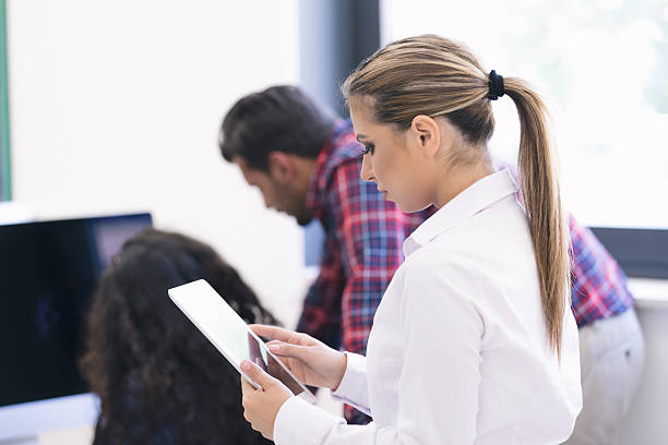 istock Smiling young women using digital tablet in the office 617593066