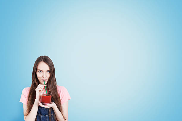 istock Girl with juice blue background 617594318