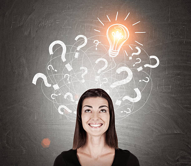 istock Smiling girl in black and light bulb with question marks 617595046