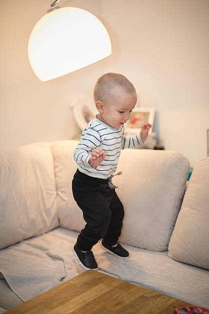 istock baby boy toddler jumping on sofa 617595132