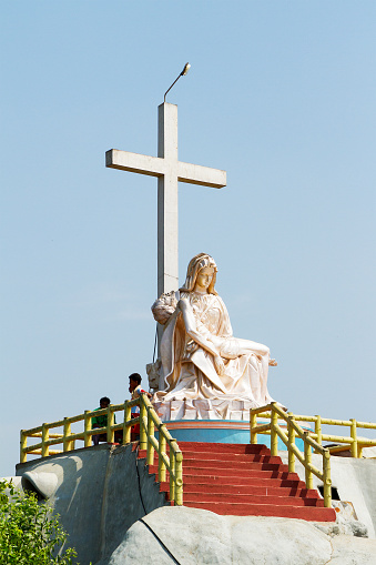 Kerala Backwaters, India - January 22, 2012: The christian cross and Lamentation of Christ monument on the small rock island in Kerala Backwaters, southern India
