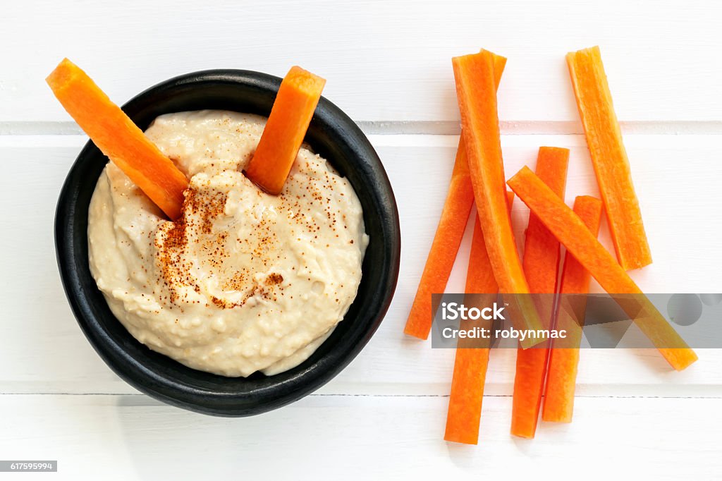 Hummus with Carrot Sticks Top View Hummus with carrot sticks.  Top view over white timber. Hummus - Food Stock Photo