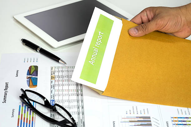 istock Hand of businessman opening annual report from envelope 617601822
