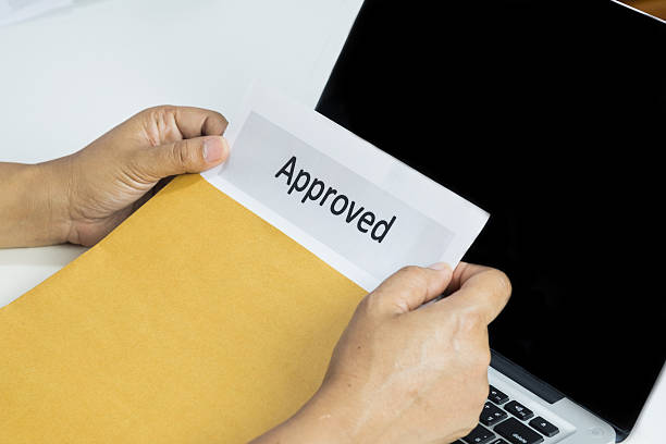istock Hand of businessman opening approved document from envelope 617601832