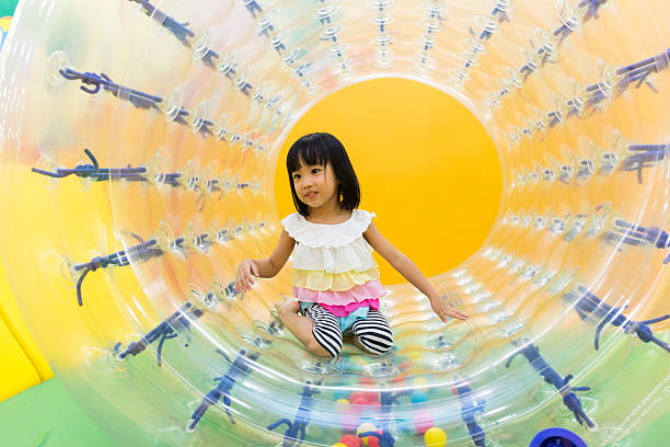 Asian Chinese Little Girl Playing Roller Wheel Asian Chinese Little Girl Playing Roller Wheel at indoor playground zorb ball stock pictures, royalty-free photos & images