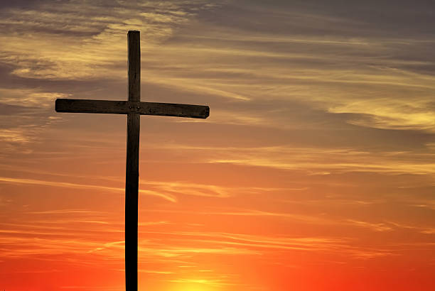 istock Christian cross over dark red sunset background 617605816