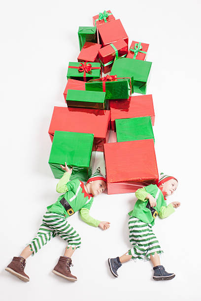 istock Boys dressed Elf costumes holding many gift boxes. Black Friday. 617608566