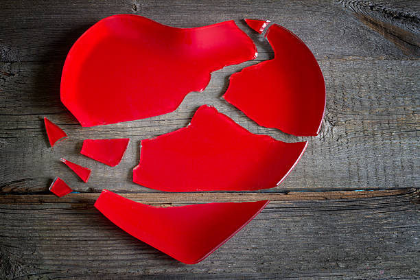 istock Broken heart red plate concept on wooden board 617609114