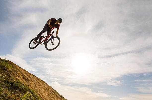 istock Below view of skillful cyclist jumping high up against sky. 617609738