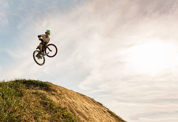 istock Below view of extreme cyclist performing invert move. 617735044