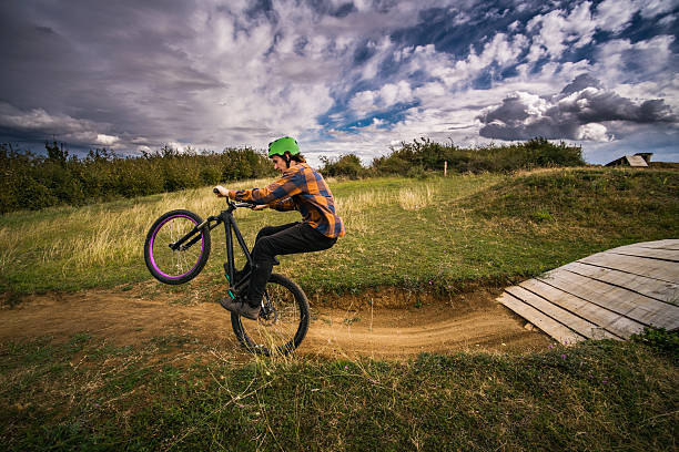 A Caucasian teenager partakes in women's motocross racing, speeding through laps on a track with jumps and berms.  Shot in Washington state, USA.