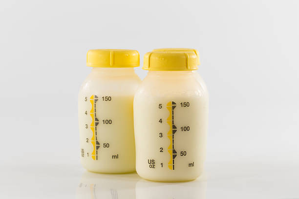 istock Baby bottle with milk and a measuring scale 617736676