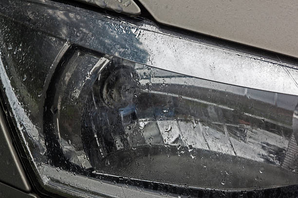 istock Patterns Textures and Shapes of Wet Front Vehicle Headlamp 617736996