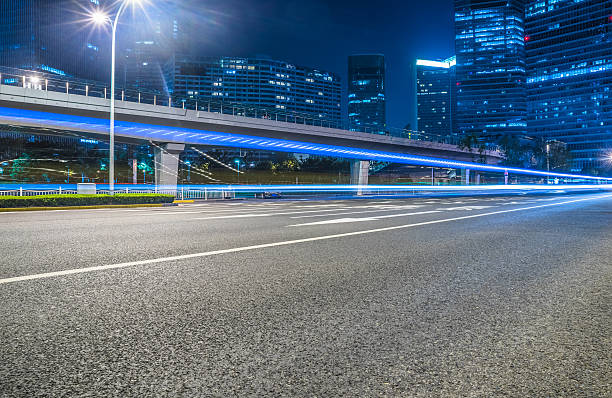 strada asfaltata vuota attraverso la città moderna. - downtown district skyline skyscraper asphalt foto e immagini stock