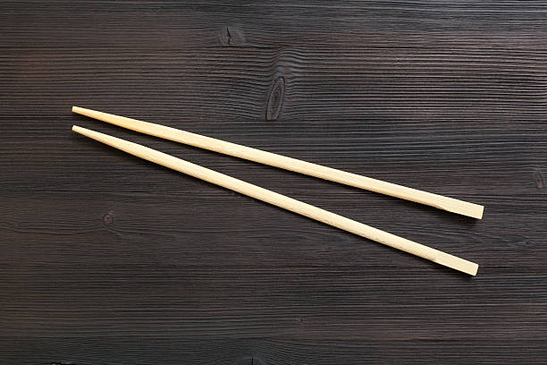 istock wooden disposable chopsticks on dark brown table 617737816