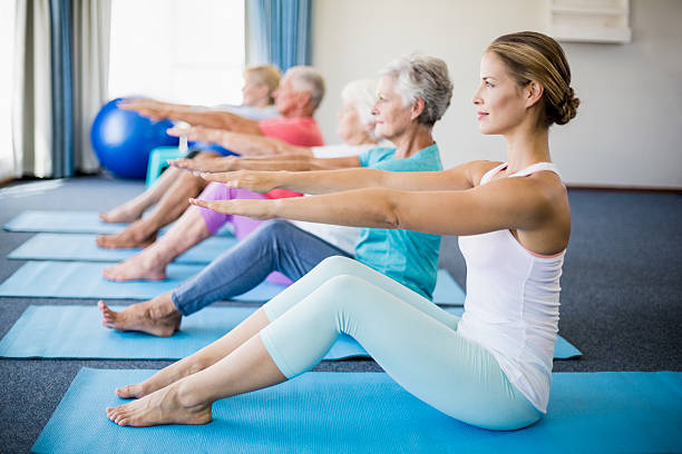 istock Instructor performing yoga with seniors 617738066