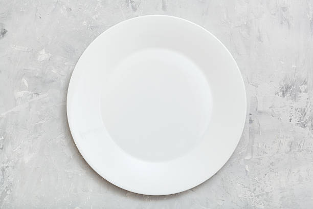 istock above view of white plate on gray concrete surface 617738366