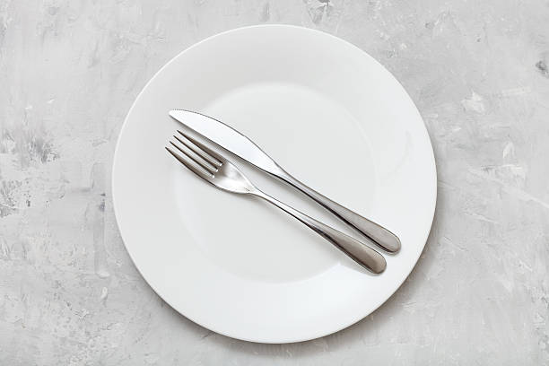 istock top view of white plate with flatware on concrete 617738410