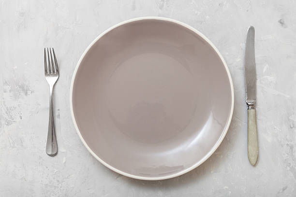 istock top view gray plate with knife, spoon on concrete 617738478