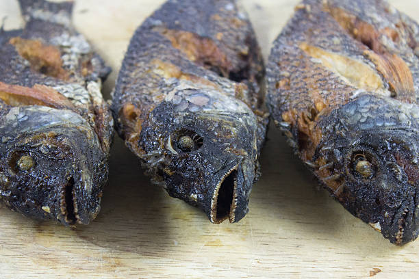 istock Three Fish body Fry on chopping Wood. 617741406
