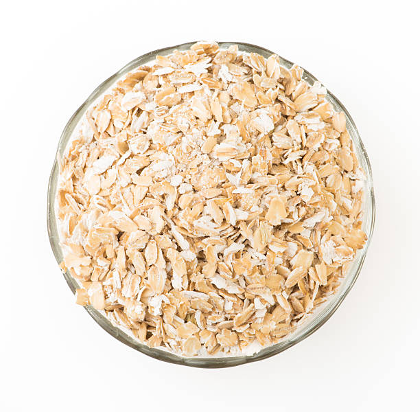 istock Oat flakes in a glass bowl isolated on white background 617743900