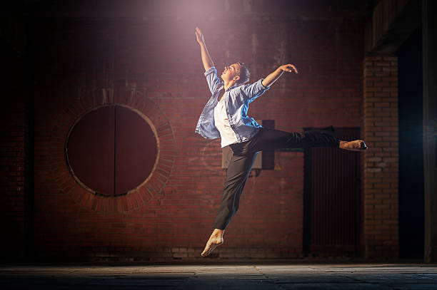 都会の背景に飛び乗るかわいいダンサー。 - ballet dancer dancing performer ストックフォトと画像